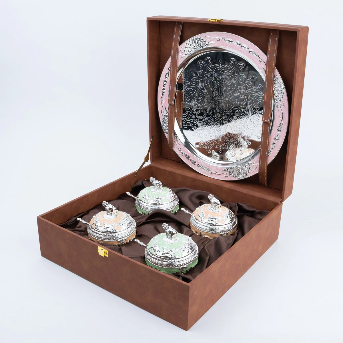 Four elephant lidded decorative containers in mint green and peach arranged on ornate silver tray