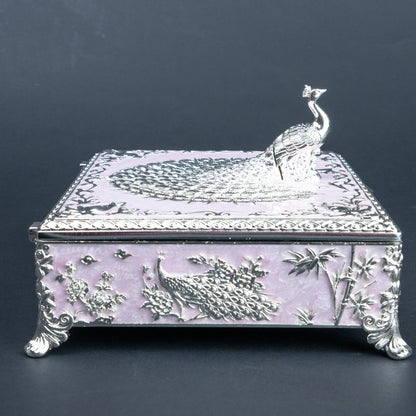 Ornate peacock jewellery box with silver detailing, floral motifs and decorative feet