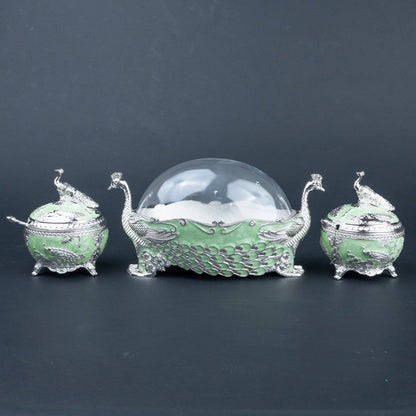 Ornate emerald green peacock dry fruit containers with silver detailing and decorative lids
