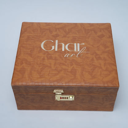 A square brown textured wooden presentation box with a gold-tone combination lock and the brand name 'Ghar art' printed in white on the lid, set against a light gray background.