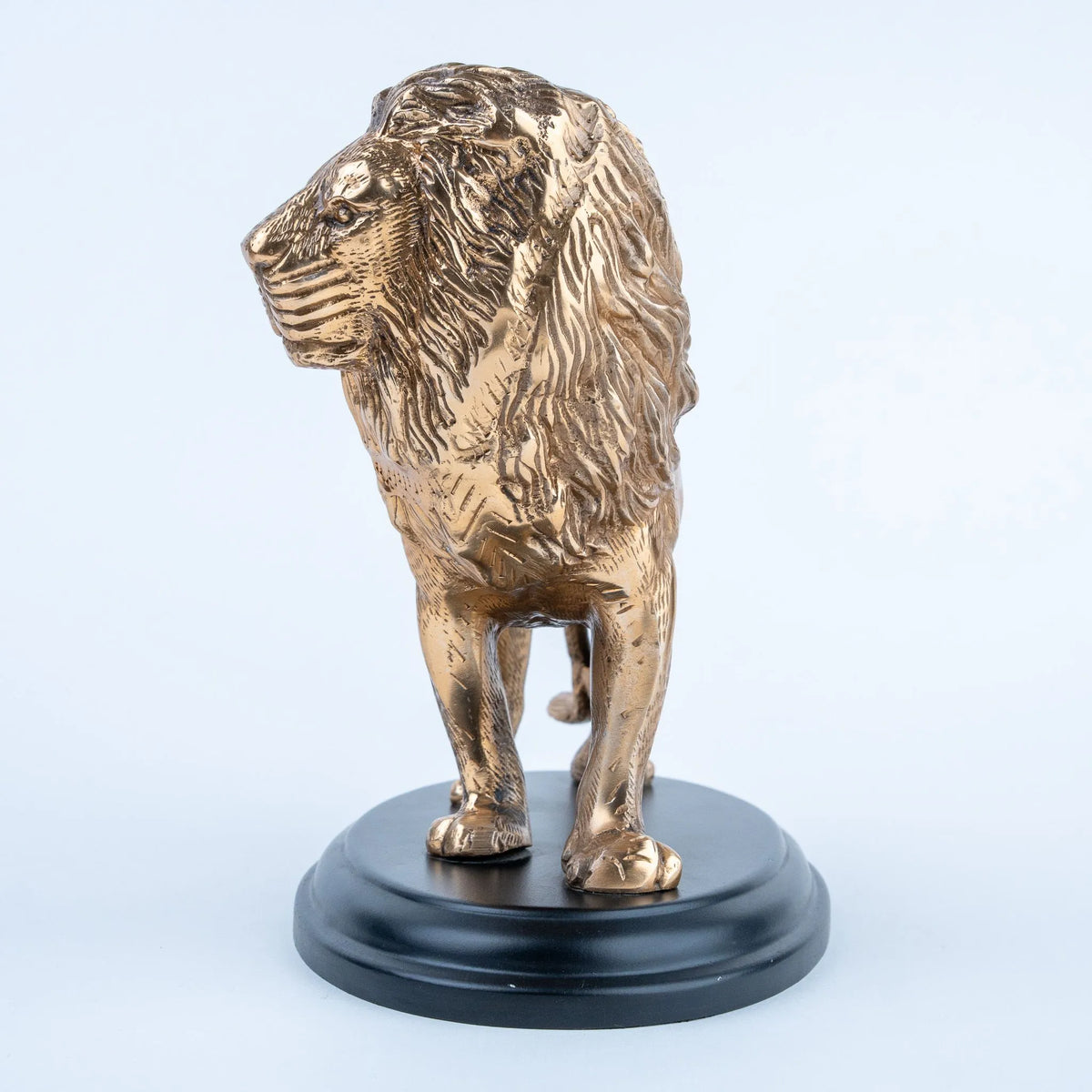 Gold lion figurine with textured mane and black oval base