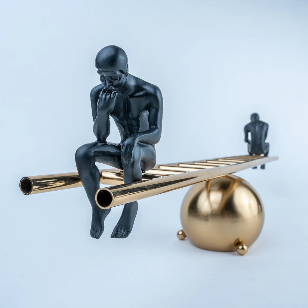 Contemporary decorative sculpture featuring a spherical gold base and linear beam.