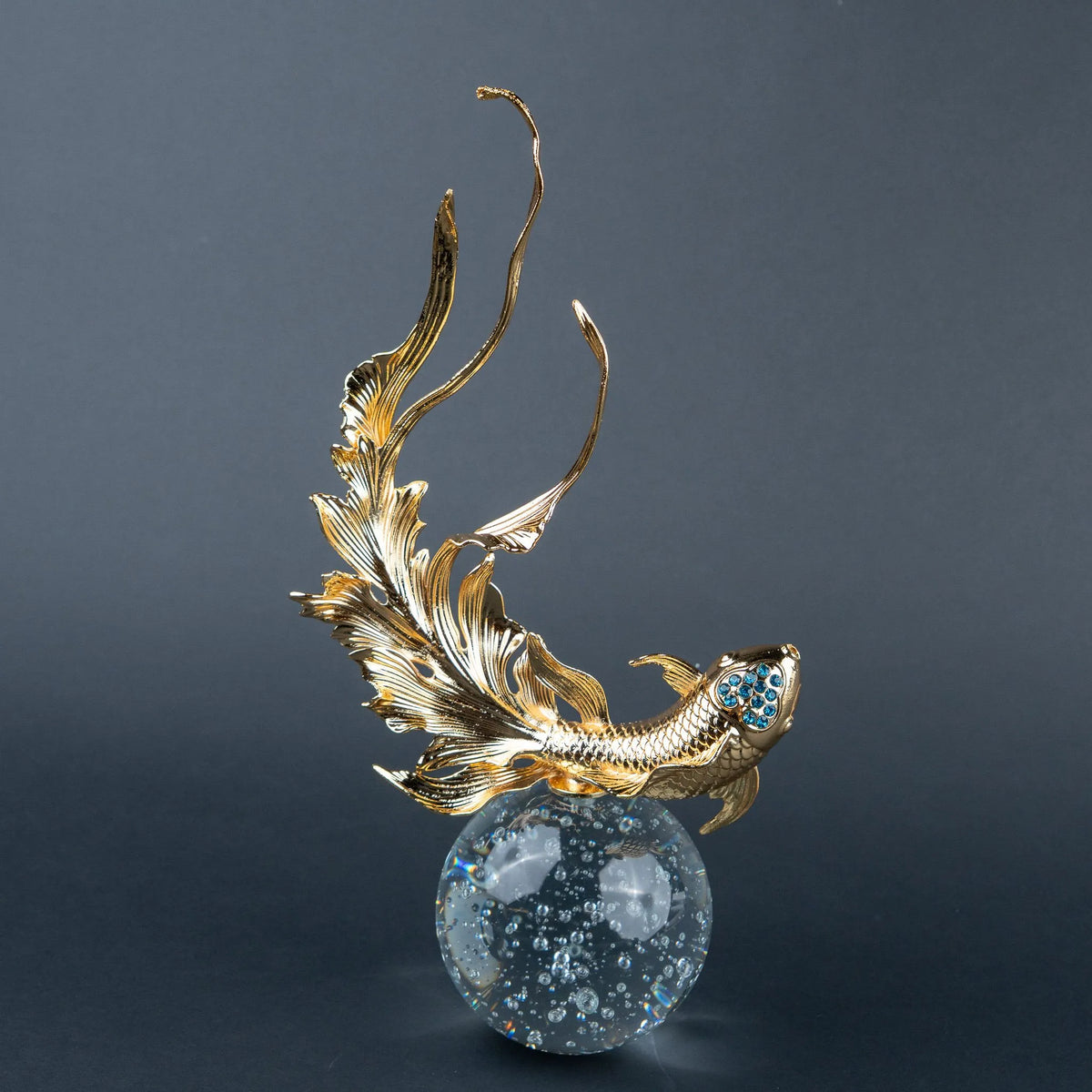 Luxury gold fish showpiece featuring detailed scales, blue embellishments and clear base.