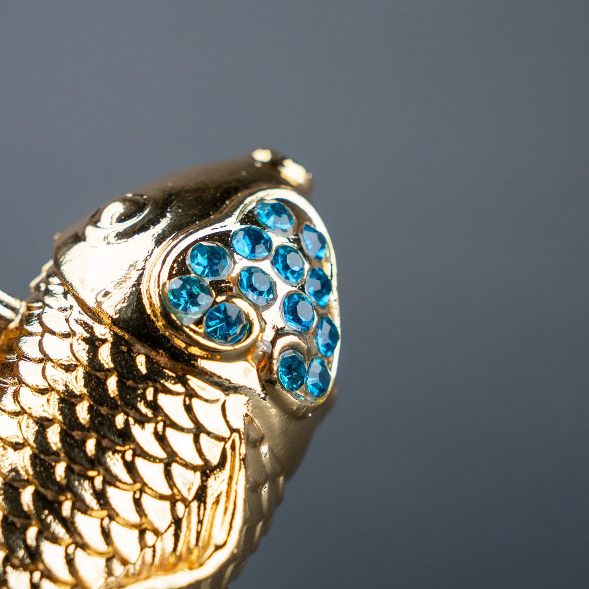 Luxury gold fish showpiece featuring detailed scales, blue embellishments and clear base.