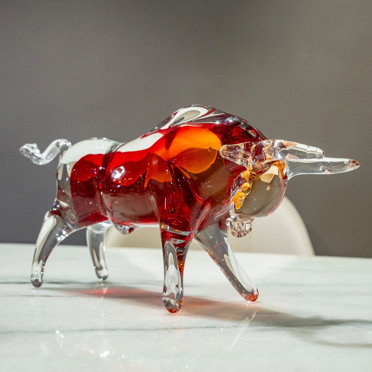 Decorative bull figurine featuring rich red, amber and clear tones