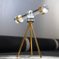 Telescope-inspired décor with clear barrel, gold details and tripod stand