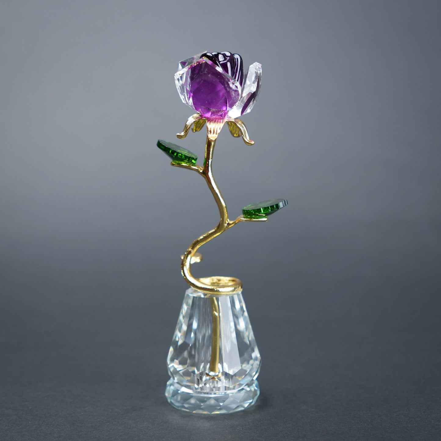 Decorative rose with purple gemstone on a gray background