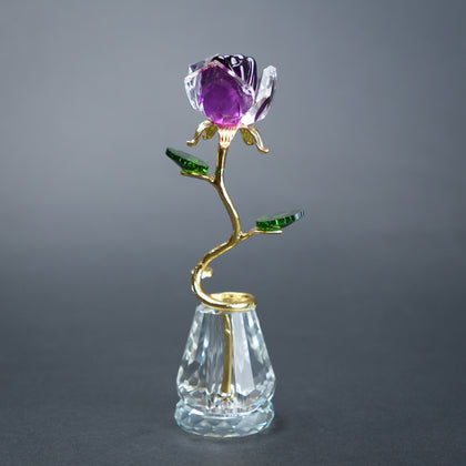 Decorative rose with purple gemstone on a gray background