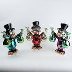 Three colorful glass figurines with top hats and bags on a white background