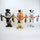 Three cartoon character figurines in gold, silver, and bronze on a white background