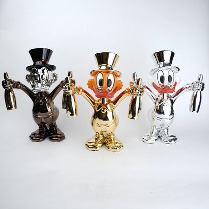 Three cartoon character figurines in gold, silver, and bronze on a white background