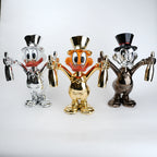 Three metallic figurines of a cartoon character with top hats on a white background