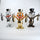 Three metallic figurines of a cartoon character with top hats on a white background