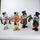 Four metallic figurines of cartoon characters with top hats and bottles on a white background