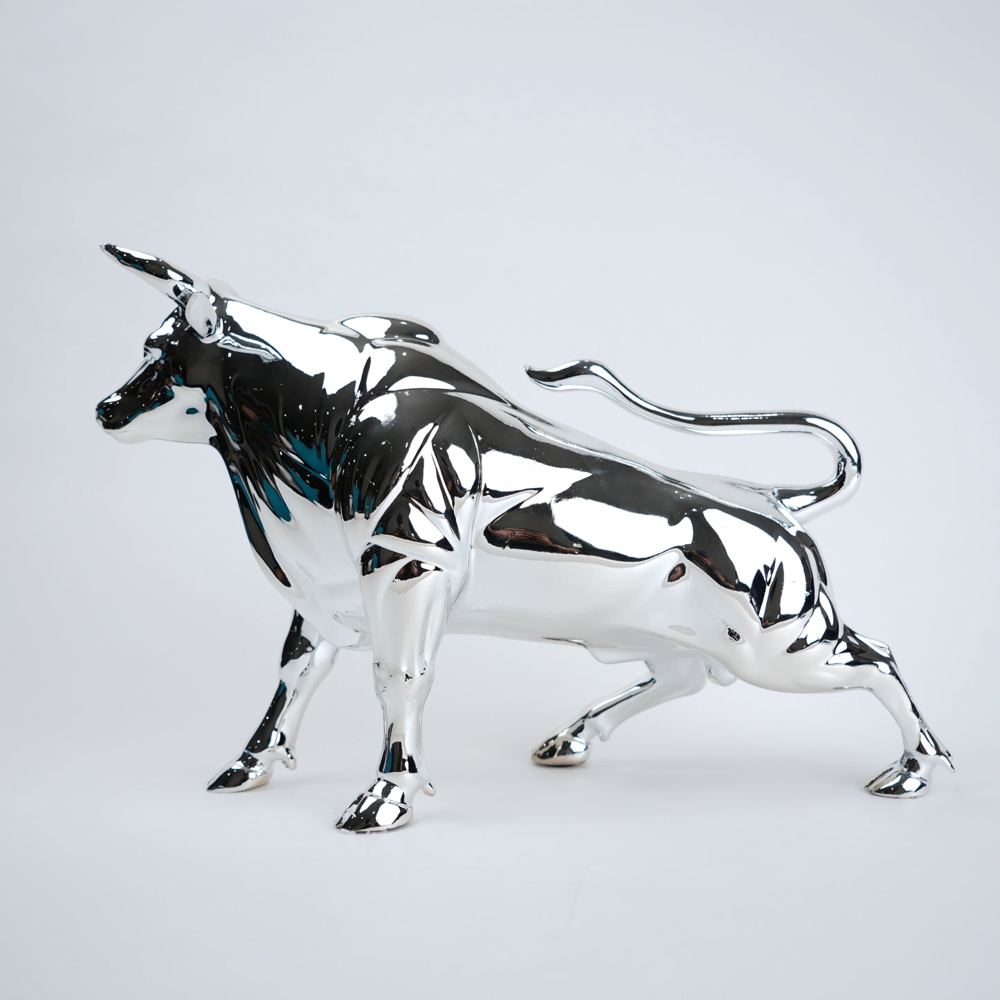 Silver bull sculpture on a light gray background