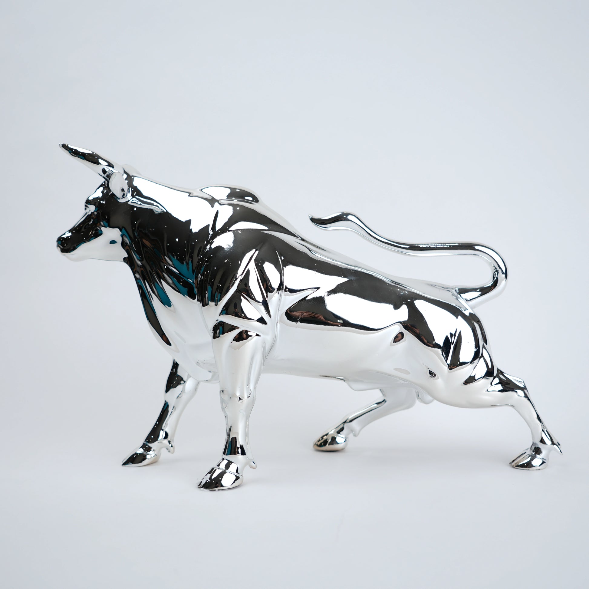 Silver bull sculpture on a light gray background