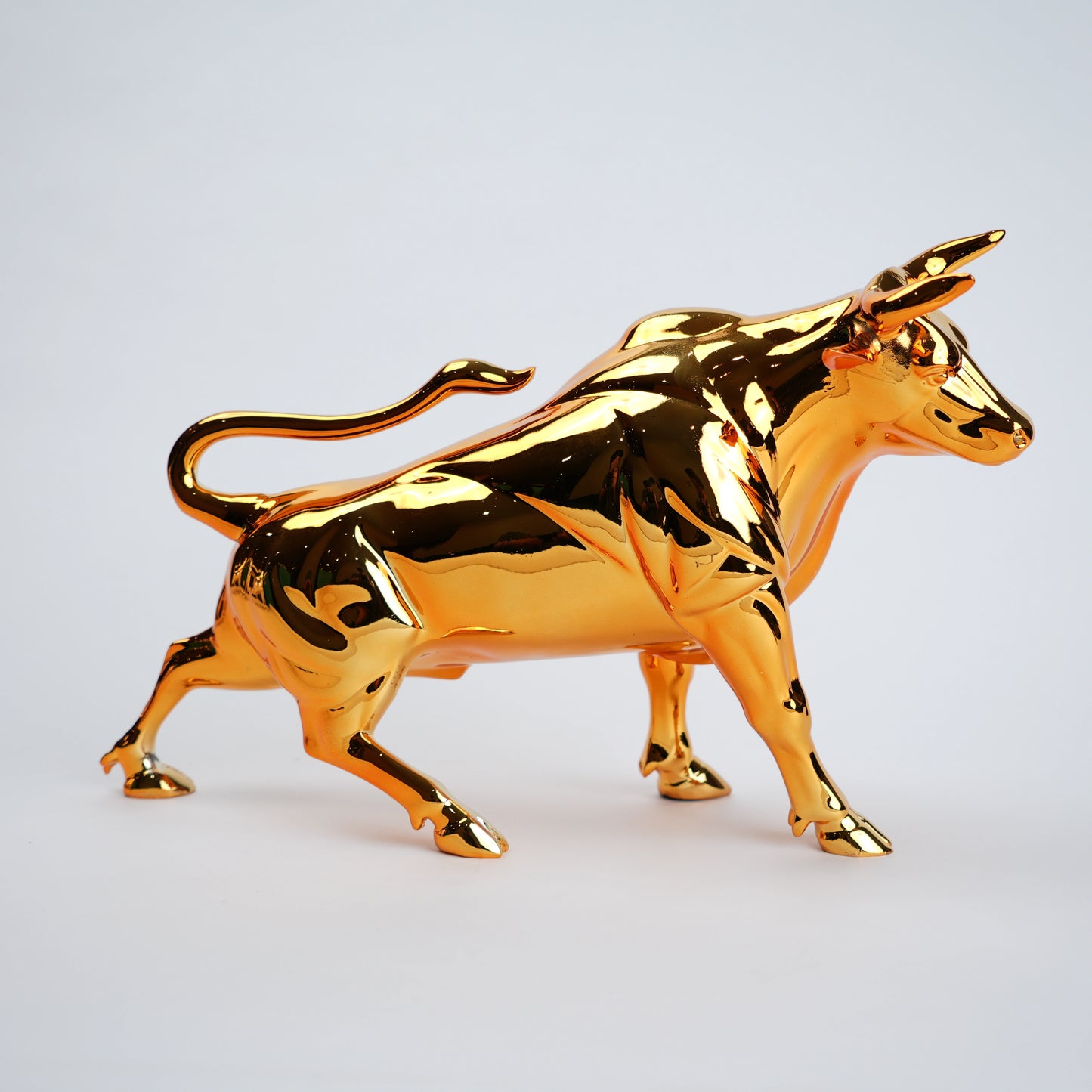 Gold bull figurine on a light gray background
