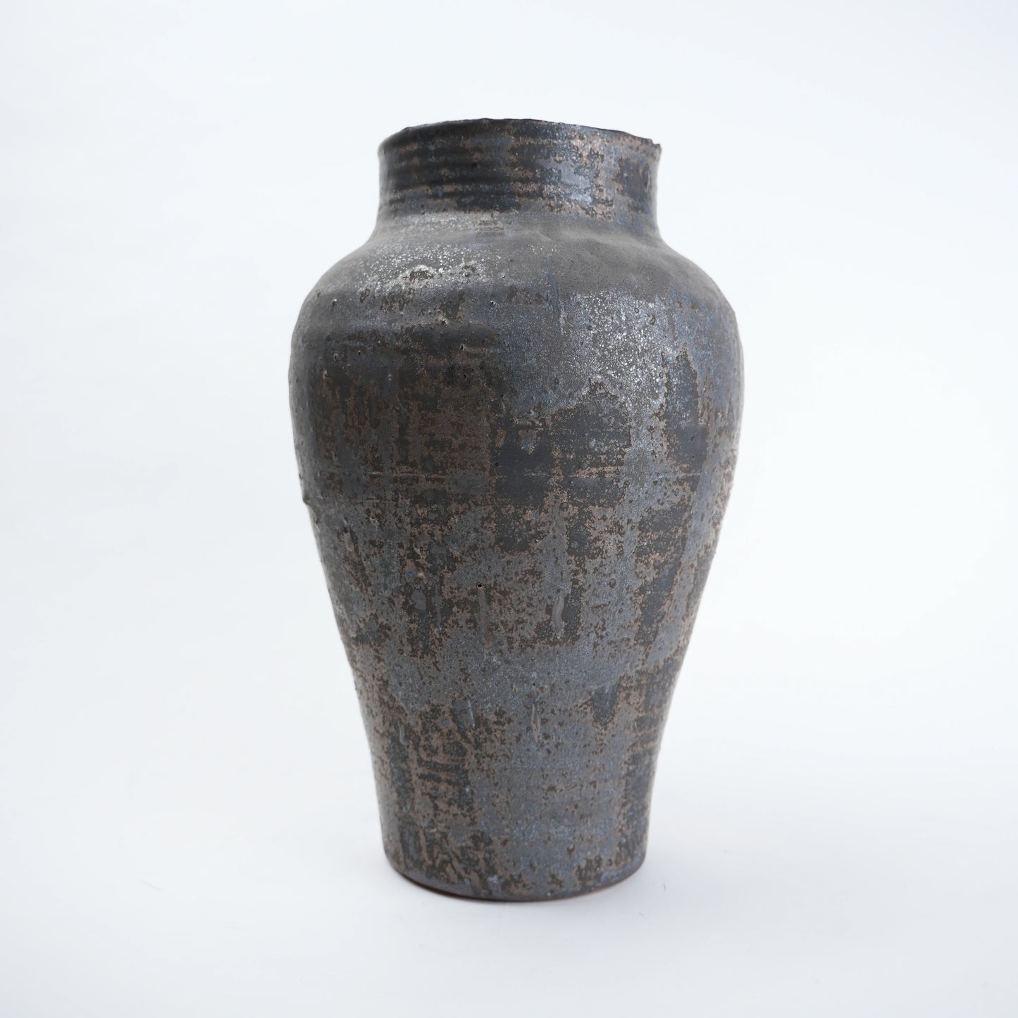 Textured black ceramic vase on a white background