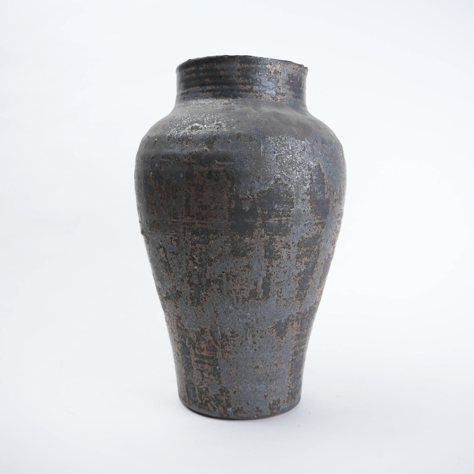 Textured black ceramic vase on a white background