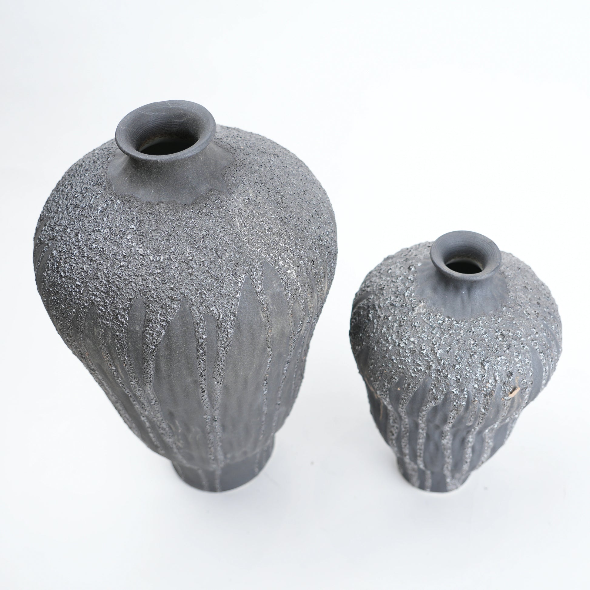 Two gray textured vases on a white background