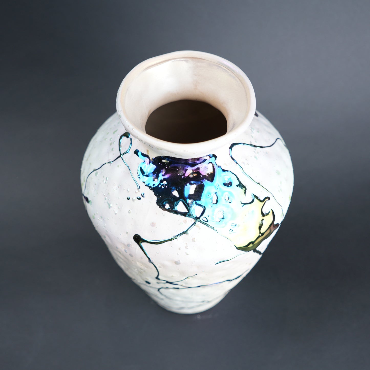 Ceramic vase with abstract designs on a dark background