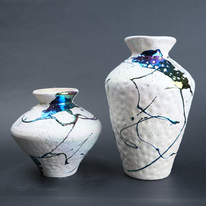 Two ceramic vases with abstract designs on a gray background