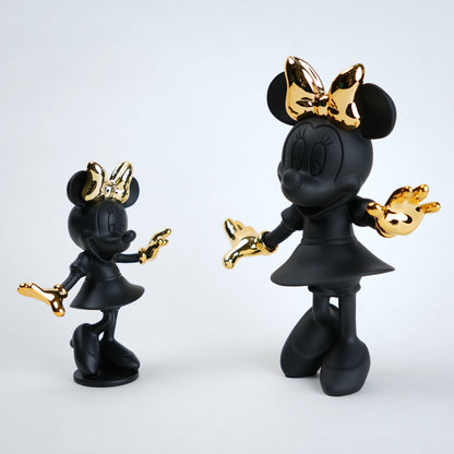 Black and gold Minnie Mouse figurine on a white background