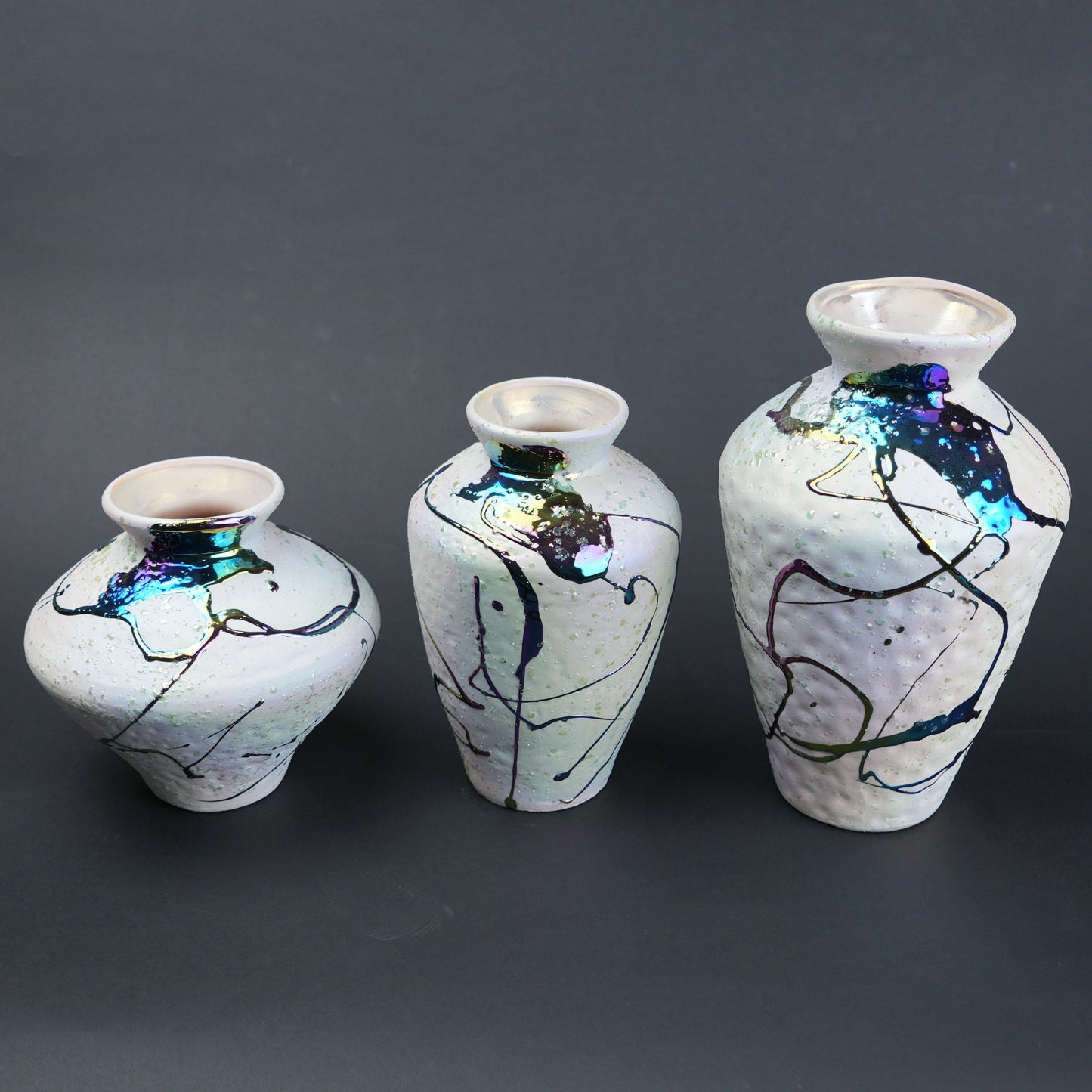 Abstract splash white vase trio on slate