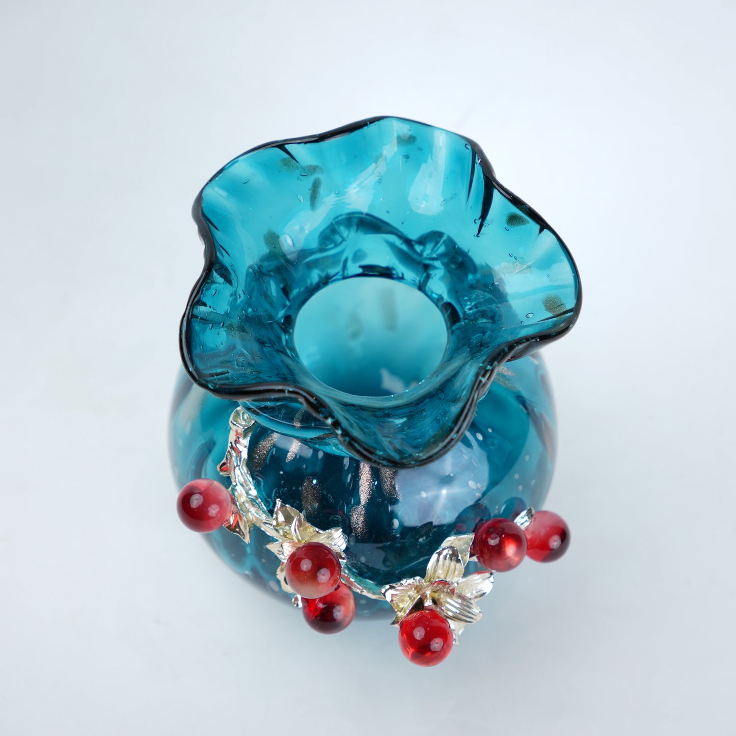 blue glass vase with decorative berry accents