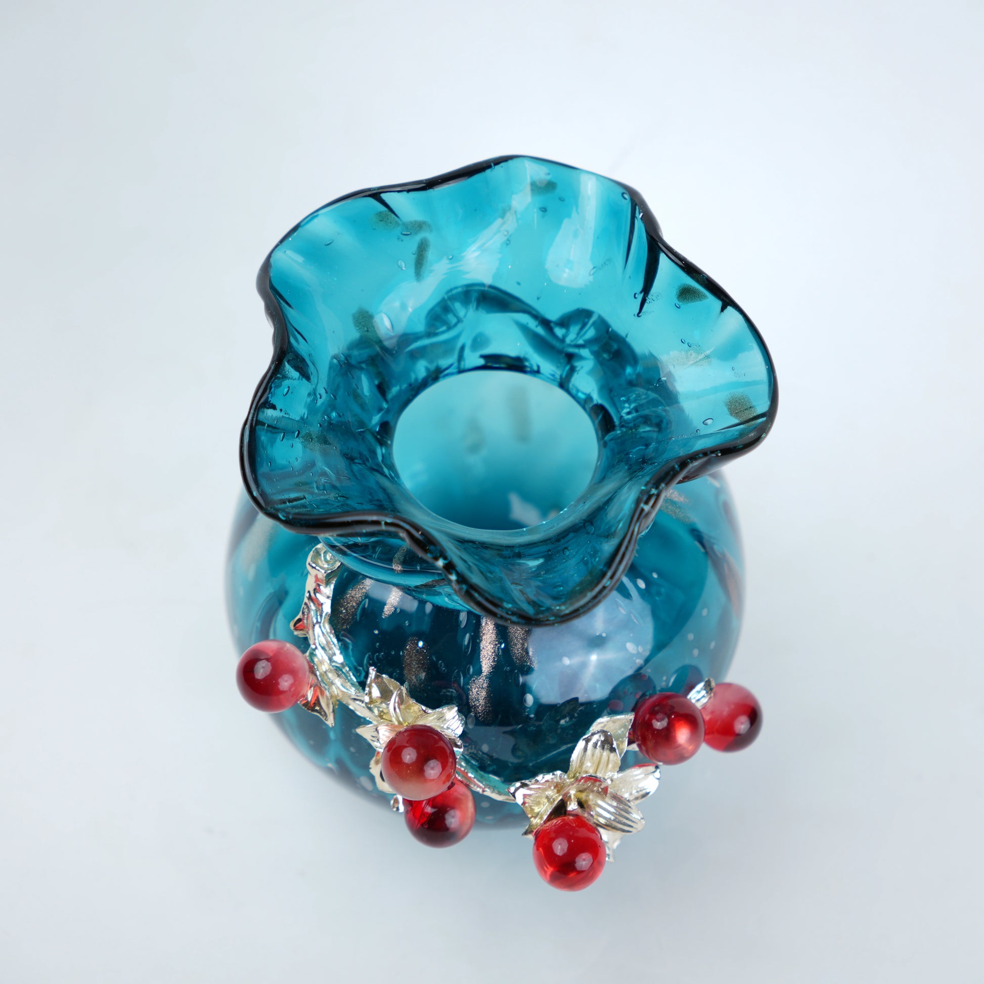 blue glass vase with decorative berry accents