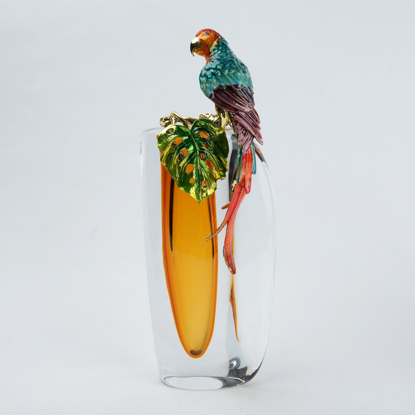 Decorative glass vase with a parrot and leaf design on a white background