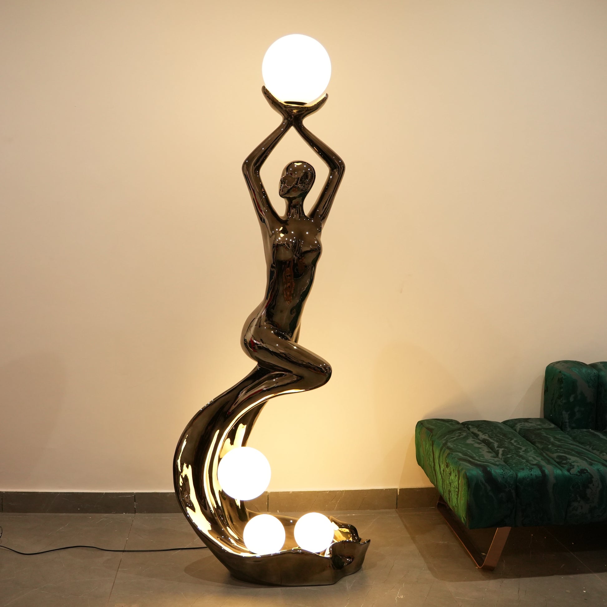 black sculptural floor lamp with human figure and orb lights