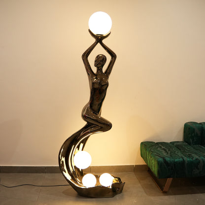 black sculptural floor lamp with human figure and orb lights