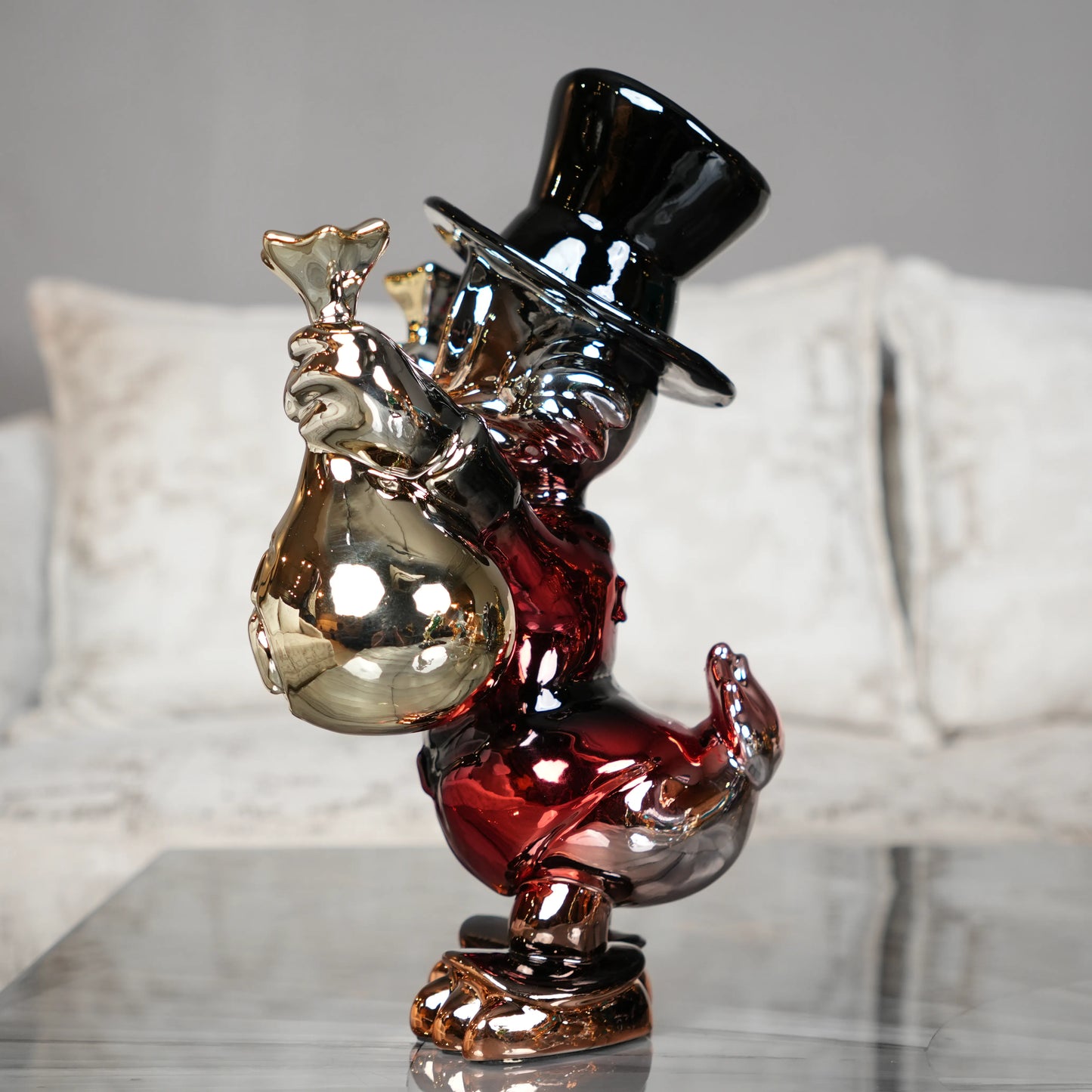 Decorative glass figure of a man in a top hat with a bag, on a reflective surface.