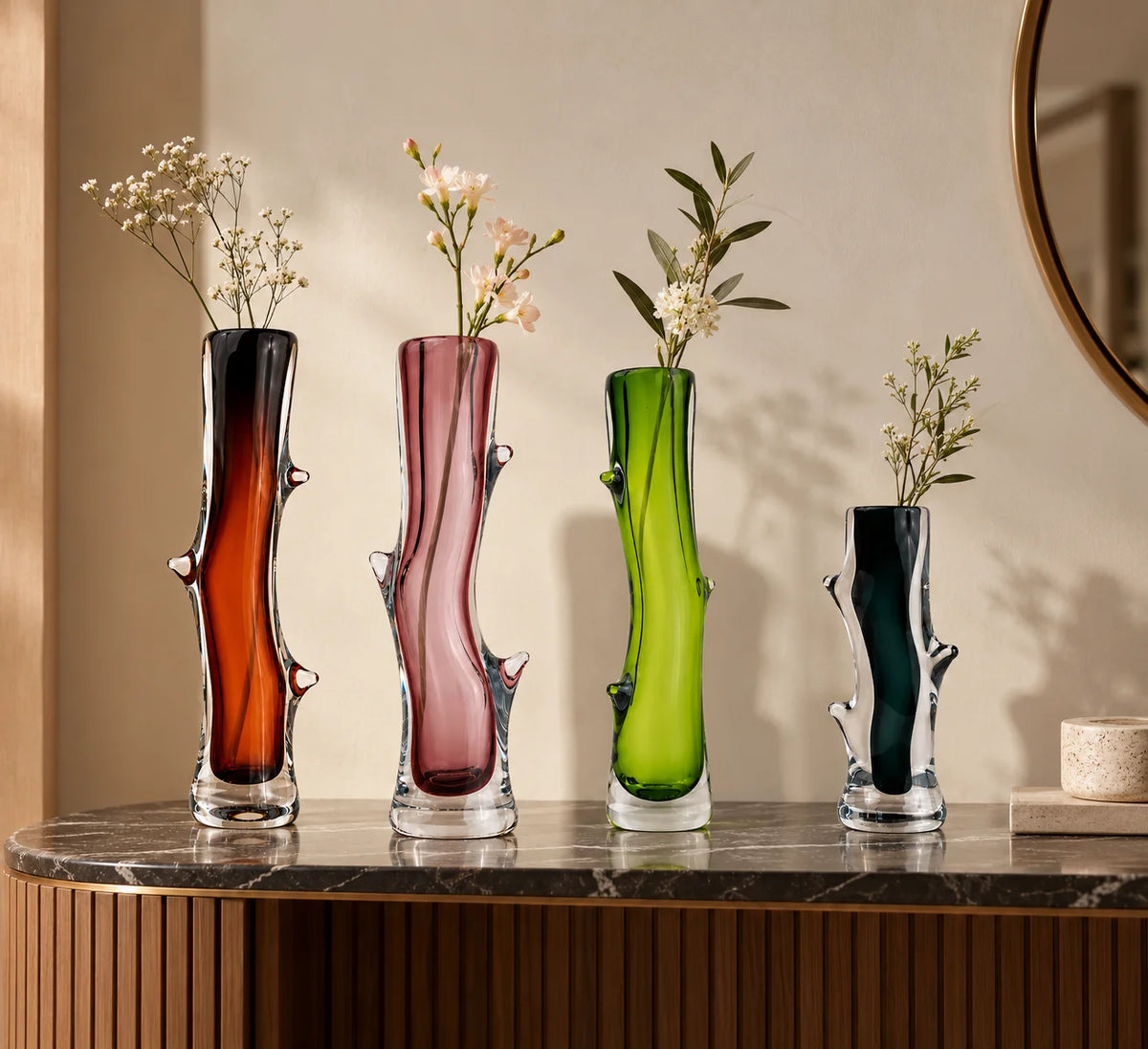 Set of four decorative glass vases in brown, pink, lime green, and charcoal, featuring artistic curves, transparent glass bases, and unique sculptural detailing.