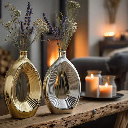 Luxury duo set of ceramic vases featuring contemporary hollow oval silhouettes in gold and silver finishes, ideal for fresh flowers, dried botanicals, console tables and modern designer interiors.