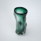 Decorative green glass vase with flared neck and dimensional textured surface featuring subtle shimmer accents in premium finish