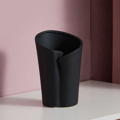 Luxury resin flower vase featuring a contemporary folded sculptural design, available in orange, white and black finishes, perfect for fresh flowers, dried botanicals and modern designer interiors.