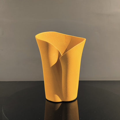 Luxury resin flower vase featuring a contemporary folded sculptural design, available in orange, white and black finishes, perfect for fresh flowers, dried botanicals and modern designer interiors.