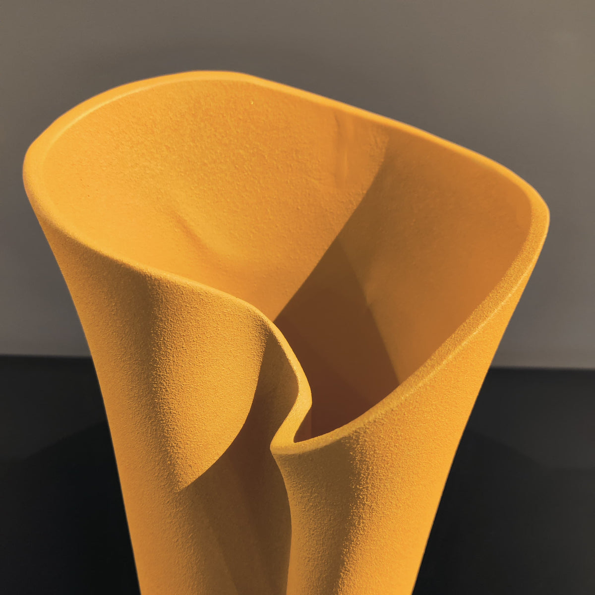 Luxury resin flower vase featuring a contemporary folded sculptural design, available in orange, white and black finishes, perfect for fresh flowers, dried botanicals and modern designer interiors.
