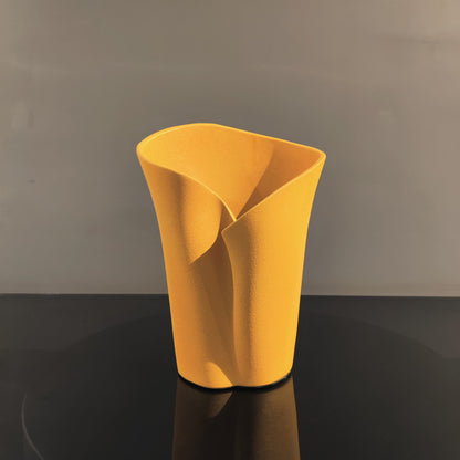 Luxury resin flower vase featuring a contemporary folded sculptural design, available in orange, white and black finishes, perfect for fresh flowers, dried botanicals and modern designer interiors.