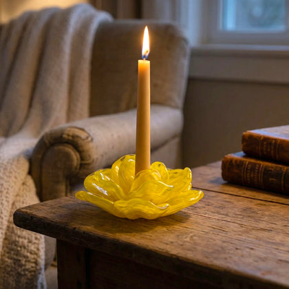 Yellow flower holder lit beside cream sofa