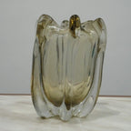 Decorative sculptural glass vase featuring fluid architectural curves and elegant translucent finish for modern living spaces