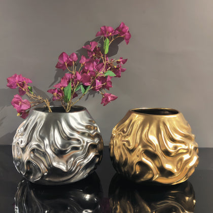 Luxury metallic ceramic decorative vases featuring sculptural fluid textures in gold and silver finishes, ideal for fresh flowers, console tables, dining spaces and modern designer interiors.