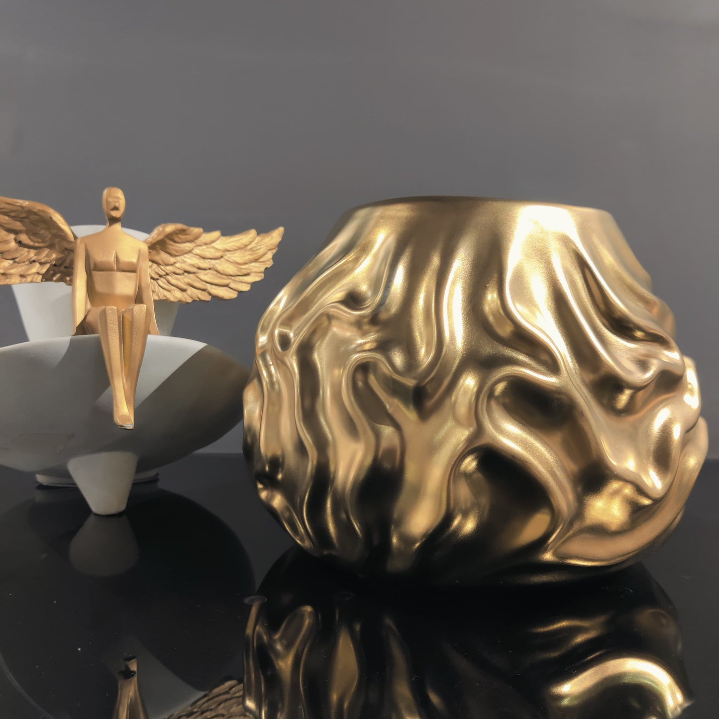 Luxury metallic ceramic decorative vases featuring sculptural fluid textures in gold and silver finishes, ideal for fresh flowers, console tables, dining spaces and modern designer interiors.