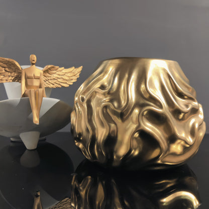 Luxury metallic ceramic decorative vases featuring sculptural fluid textures in gold and silver finishes, ideal for fresh flowers, console tables, dining spaces and modern designer interiors.