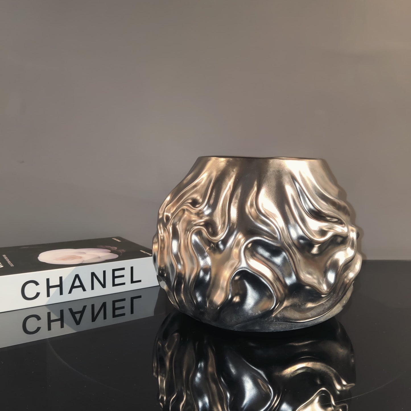 Luxury metallic ceramic decorative vases featuring sculptural fluid textures in gold and silver finishes, ideal for fresh flowers, console tables, dining spaces and modern designer interiors.