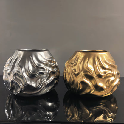 Luxury metallic ceramic decorative vases featuring sculptural fluid textures in gold and silver finishes, ideal for fresh flowers, console tables, dining spaces and modern designer interiors.