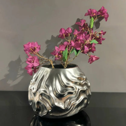 Luxury metallic ceramic decorative vases featuring sculptural fluid textures in gold and silver finishes, ideal for fresh flowers, console tables, dining spaces and modern designer interiors.