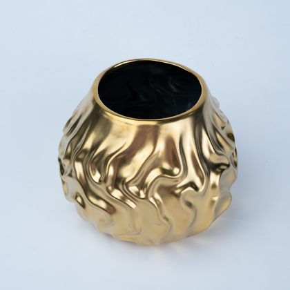 A metallic gold ceramic vase with a textured, organic wavy pattern and a glossy black interior, shown on a clean white background.